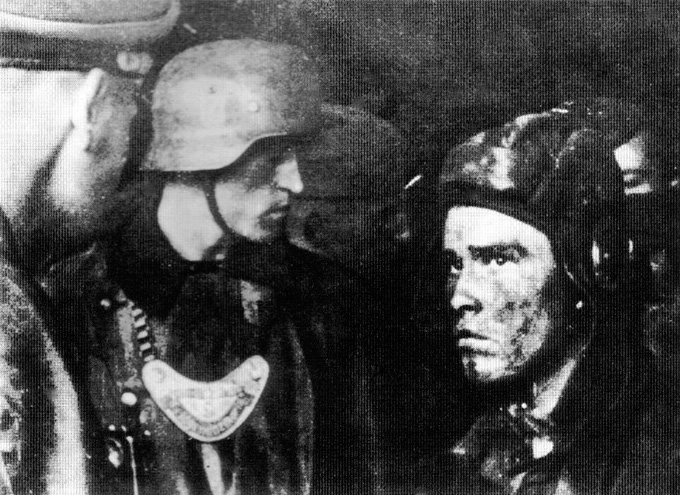 Полевые жандармы СС полка «Лейбштандарт СС Адольф Пятлер» допрашивают пленного советского танкиста. Унтер-офицер одет в непромокаемый плащ, с сигнальным фонариком, подвешенным к пуговице на кожаном ремешке.